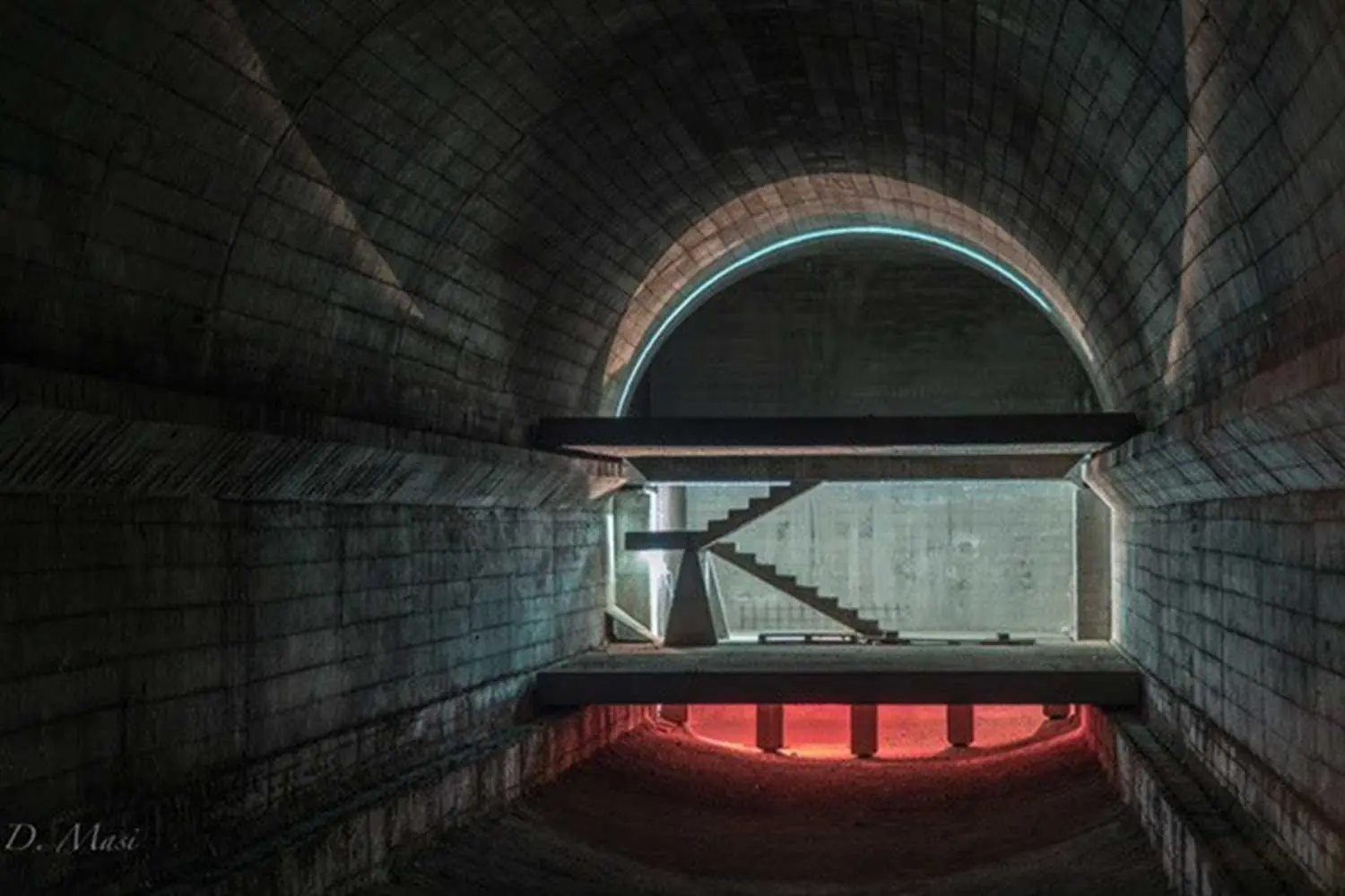 A red-lit vaulted tunnel deep inside the Soratte Bunker