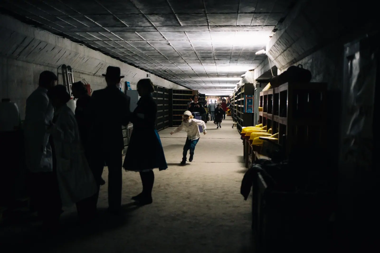 Players in white coats moving down a bunker corridor