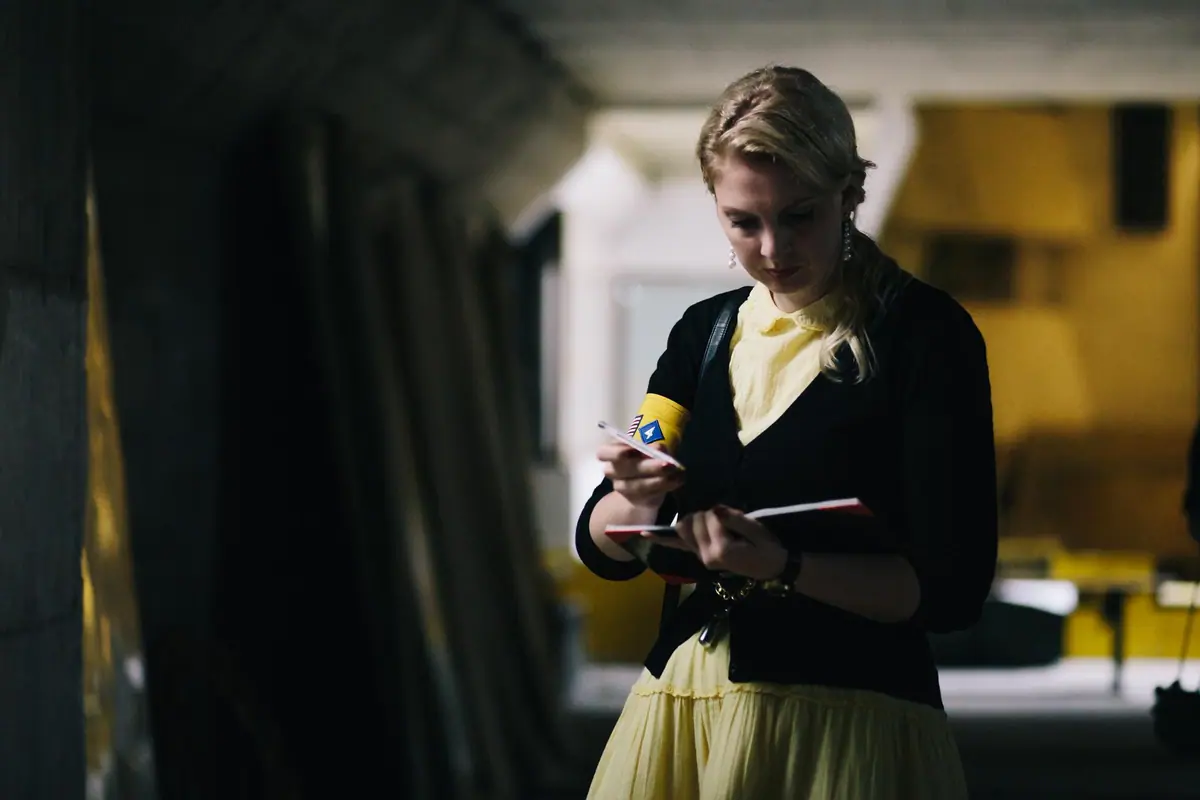A participant writing at a desk in warm lamplight