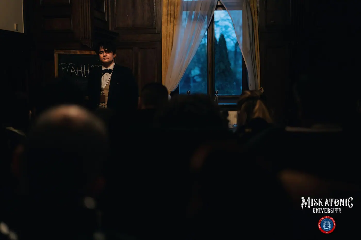 A lecture in progress in a darkened hall
