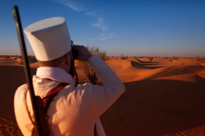 A character in white uniform scanning the horizon