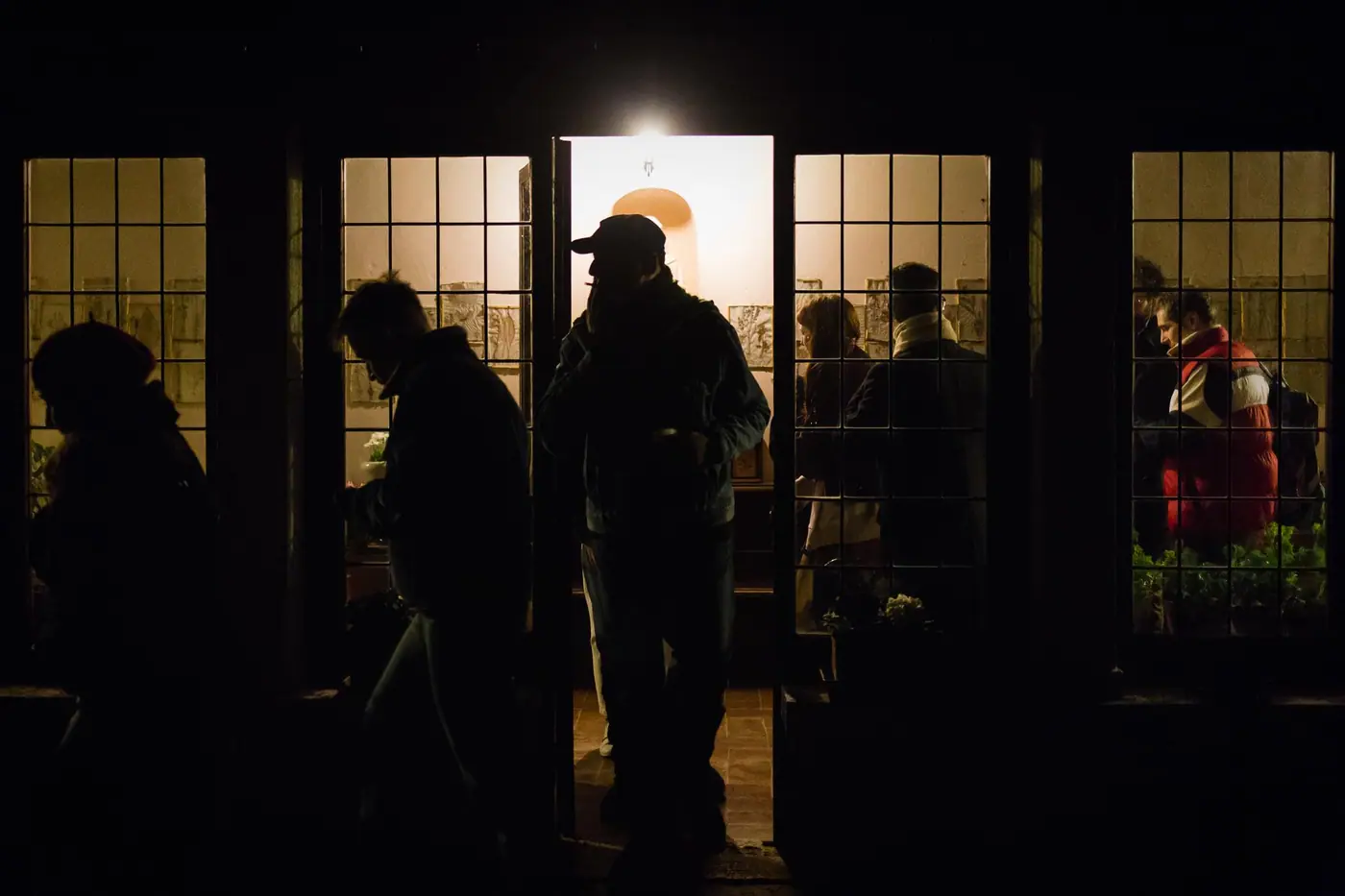 Silhouettes in a lit doorway at night