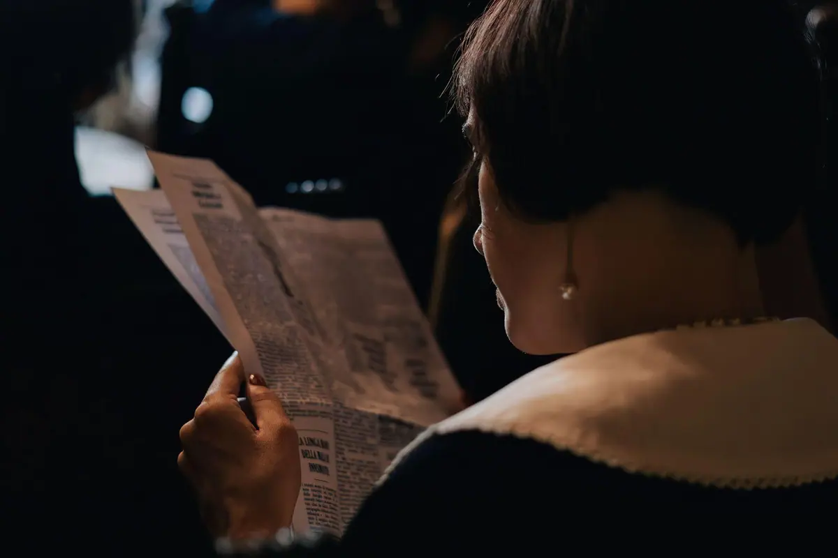 A character reading a letter by torchlight