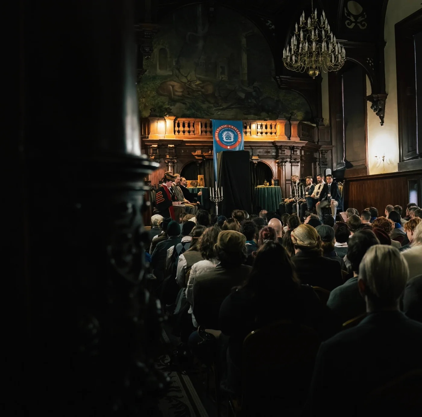 The university gathered in the great hall for the opening address, the seal of Miskatonic hung above the stage