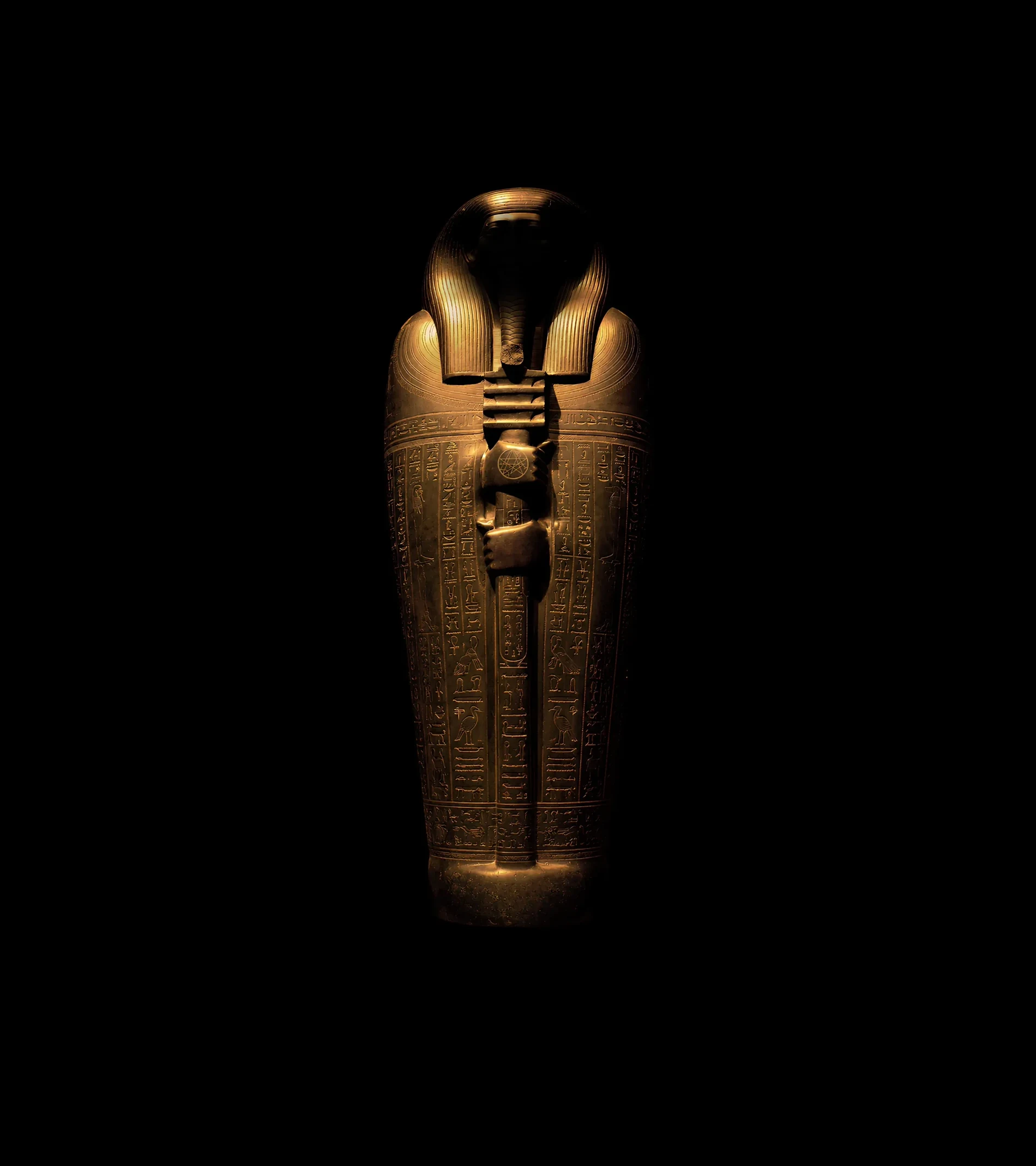 The sealed gilded sarcophagus standing in the dark, an alien sign cut into its crossed hands
