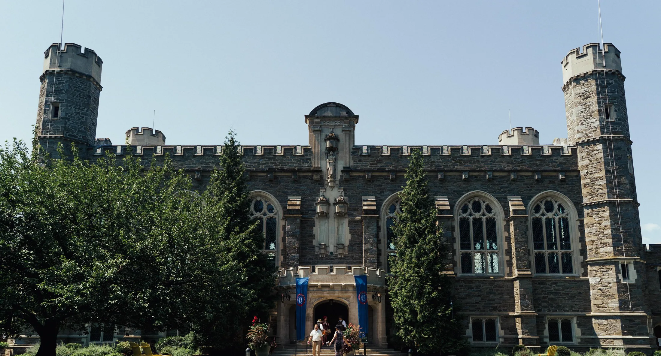 The crenellated neo-gothic facade of the campus at the end of a long path
