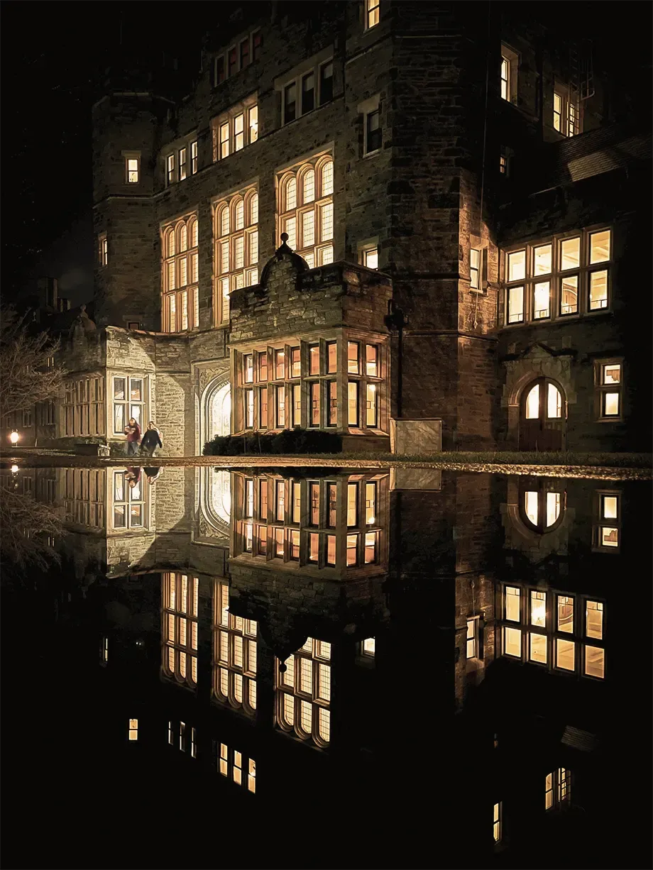 Lit windows reflected in water at night