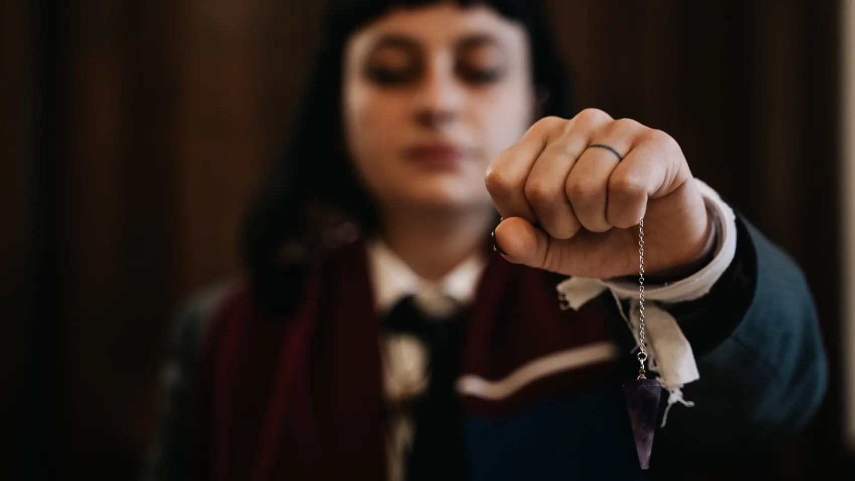 A student holds a pendulum over her notes