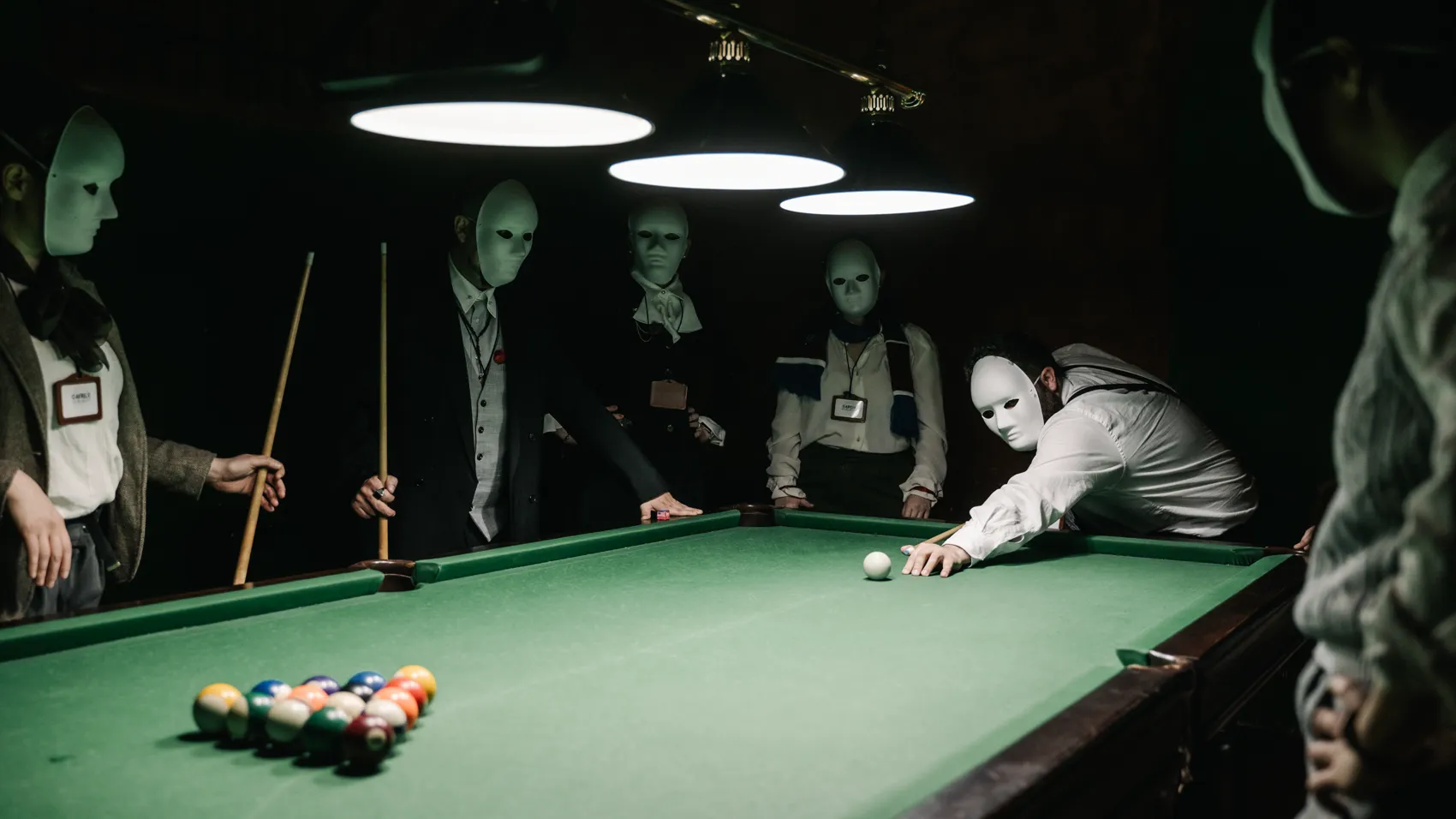 Masked players around a billiard table