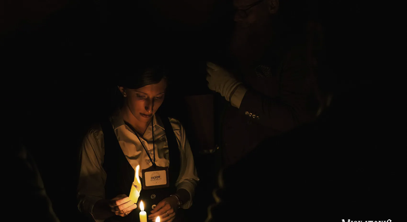 A woman lights candles in the dark