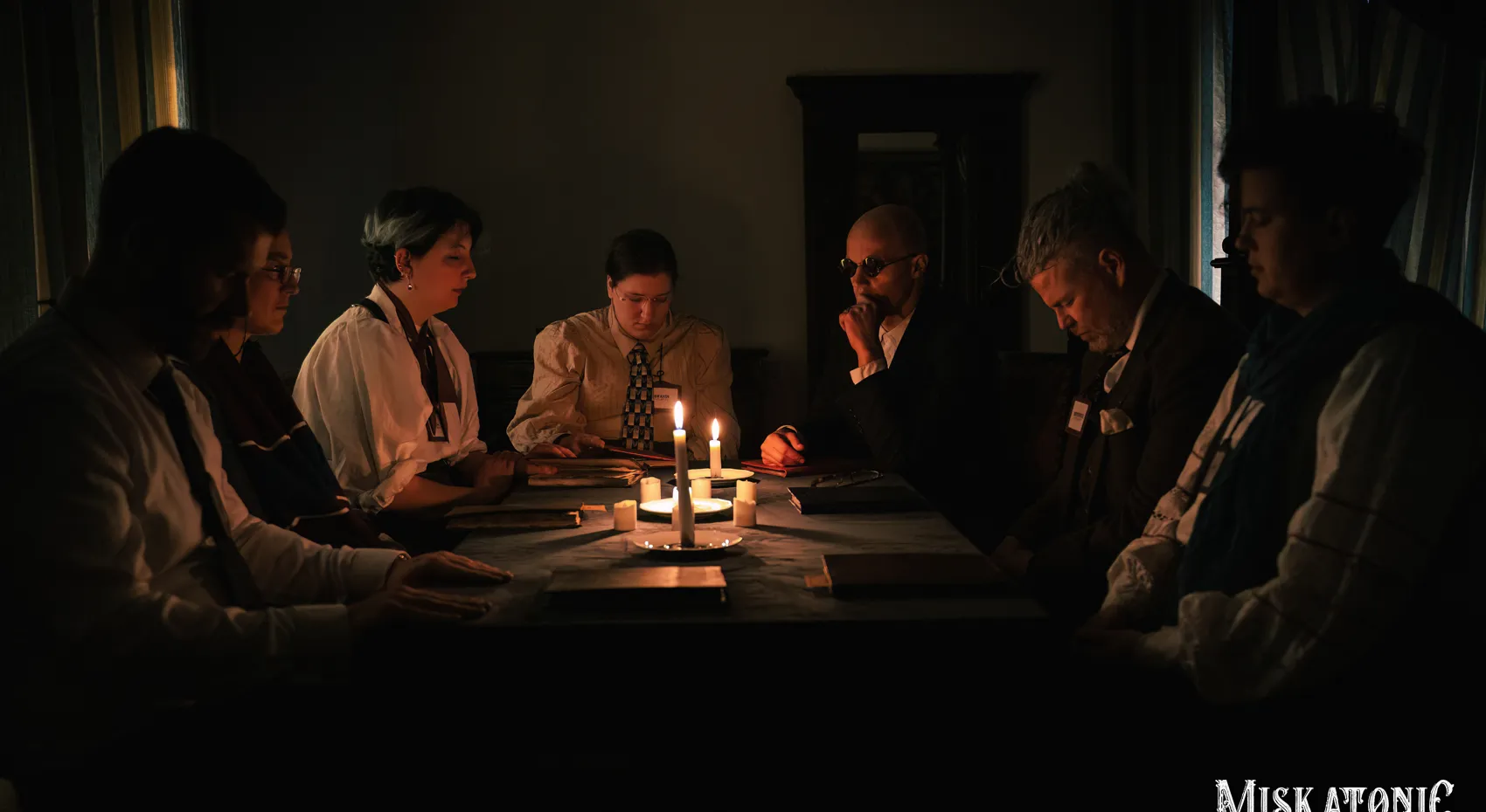 A circle of hands around a single candle