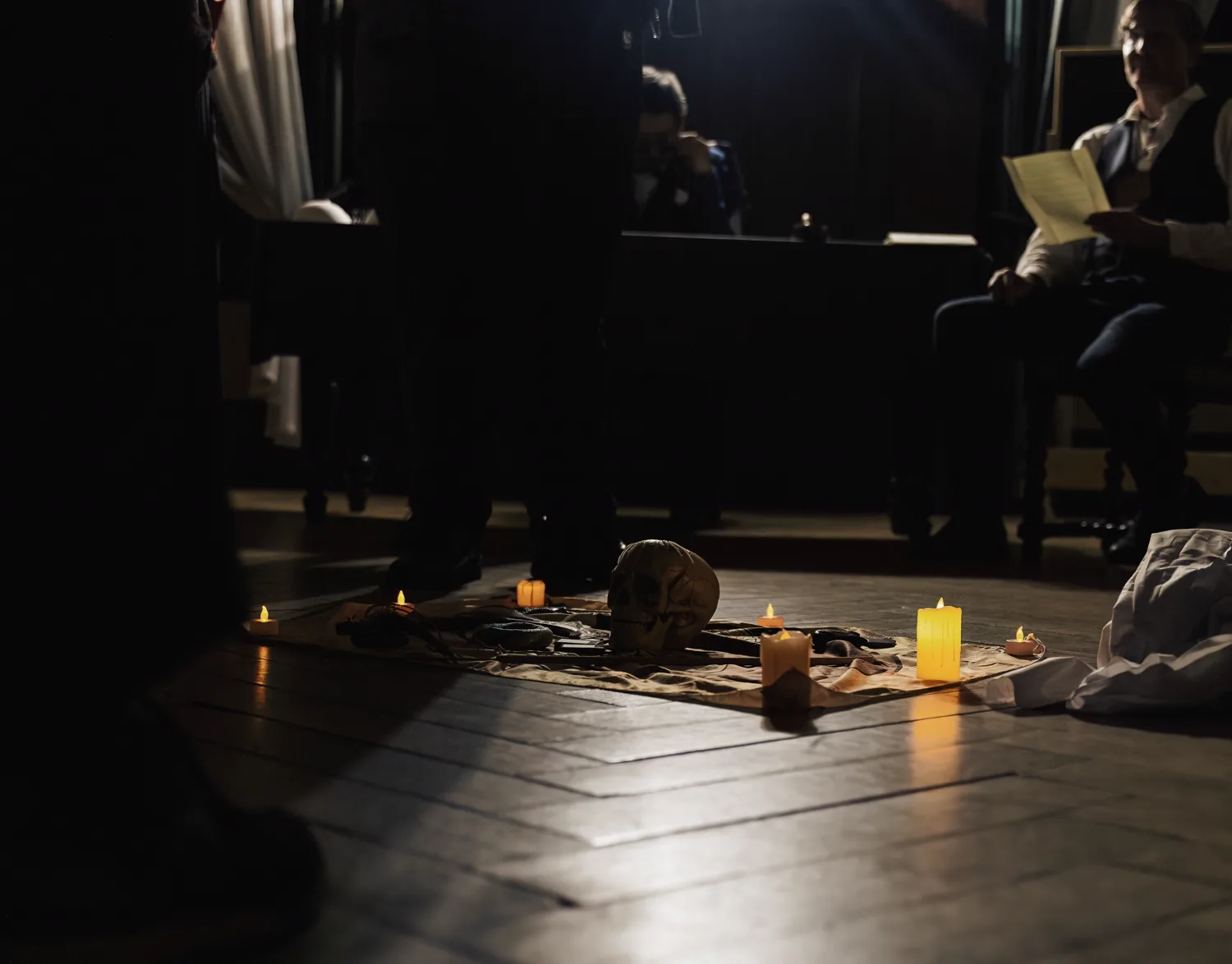 Candles and a skull laid out on the floor of a dark hall